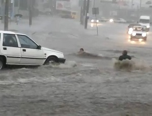 Бурный водный поток унес двух одесситов под колеса автомобилей (ВИДЕО)