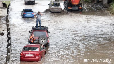 На затопленном участке дороги автомобили уходят под воду